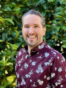 Image of Joshua Lanam standing in front of a tree